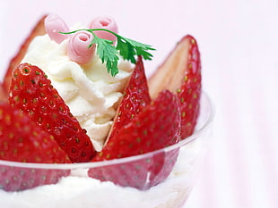 sliced strawberry with whip cream on clear glass bowl
