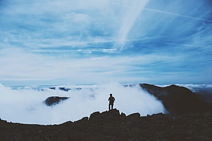 man standing on rock cliff