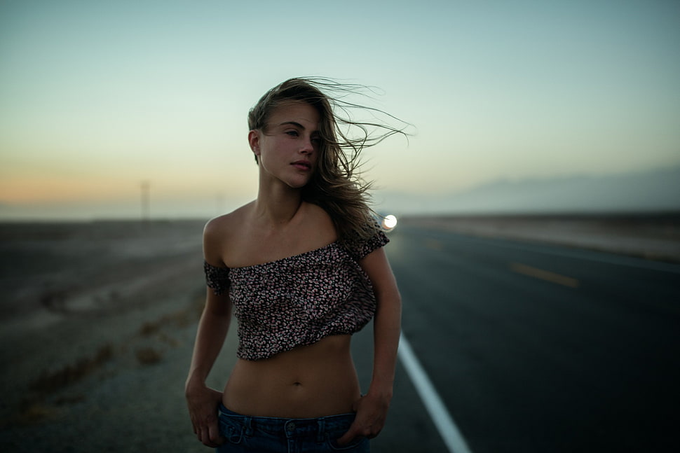 woman wearing crop top standing in middle of road during daytime HD wallpaper
