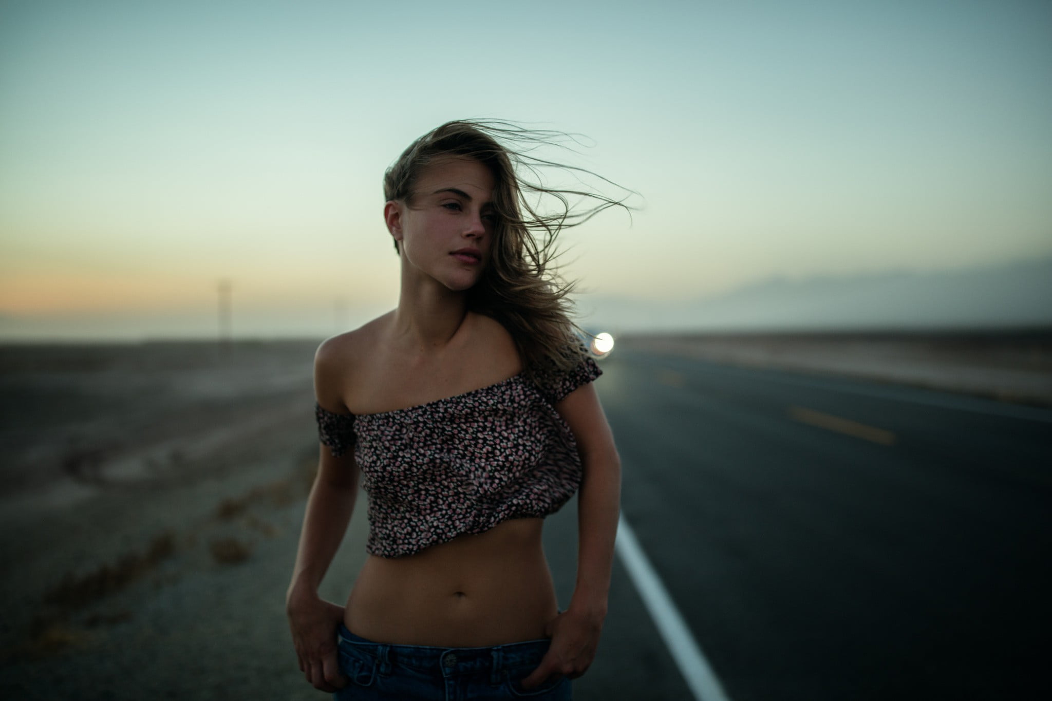 woman wearing crop top standing in middle of road during daytime