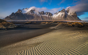brown and white mountain surrounded by sand, iceland