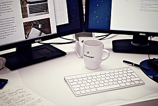 white ceramic mug near Dell monitor