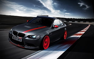 black BMW car travelling on a racing tarmac