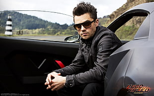 man wearing black leather jacket sitting on black coupe