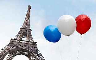 Eiffel tower Paris with white, blue, and red balloons at daytime