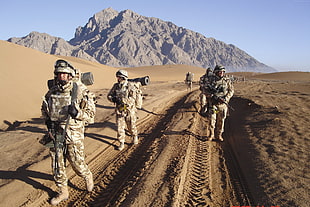 soldier walking on desert during daytime