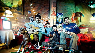 4 men band member sitting on red sofa