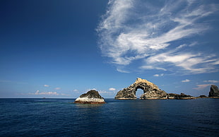 arch rock beside body of water
