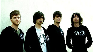 four men wearing black jackets