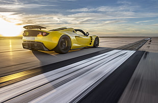 timelapse photography of yellow sports car under white clouds