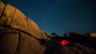 red tent on rock at nighttime