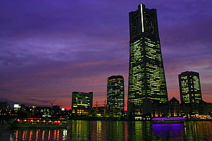 photography of high-rise building under purple sky during night time