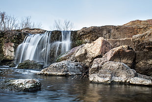 photo of cascading waterfall near brown trees