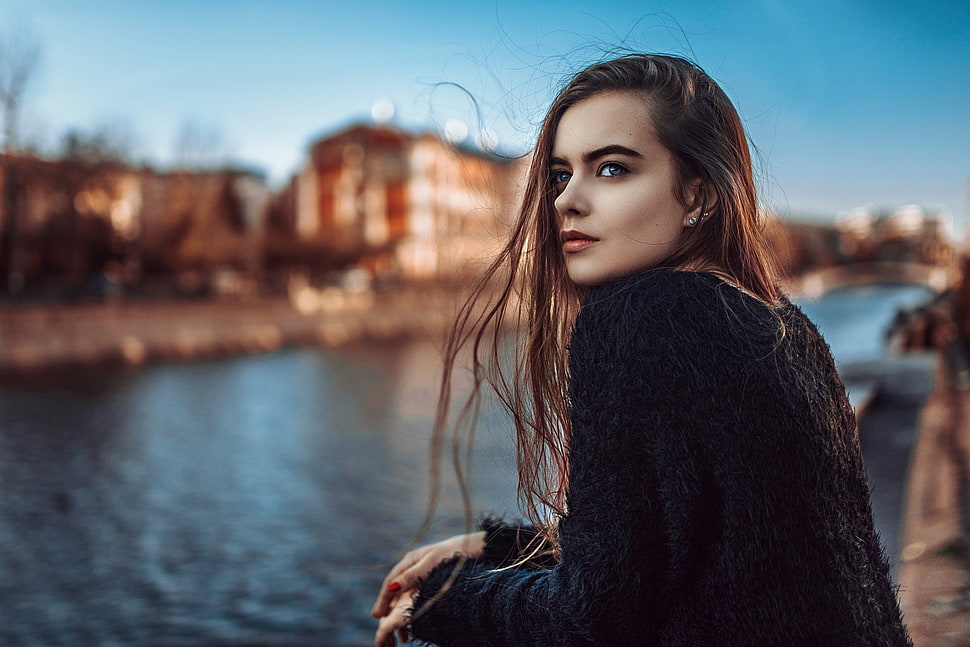 woman in black cardigan standing by the river selective focus photo HD wallpaper