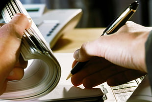 person writing on cheque