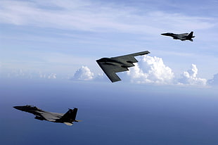 three black fighter planes in flight