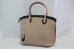 brown leather tote bag on gray textile