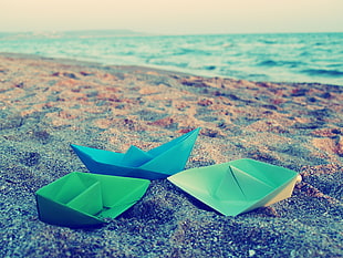 three paper boat on sea shore