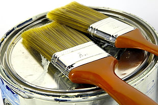 closeup photo of brown handled paint brushes on paint can