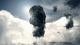 grey rock formation surrounded with clouds greyscale photography