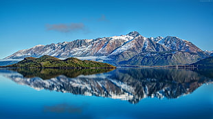 landscape photography of reflection of mountains on body of water under blue sky during daytime