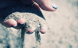 selective focus photography of person holding sand