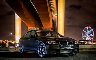 black BMW sedan under bridge