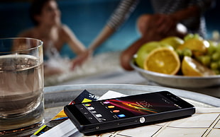 smartphone beside drinking glass