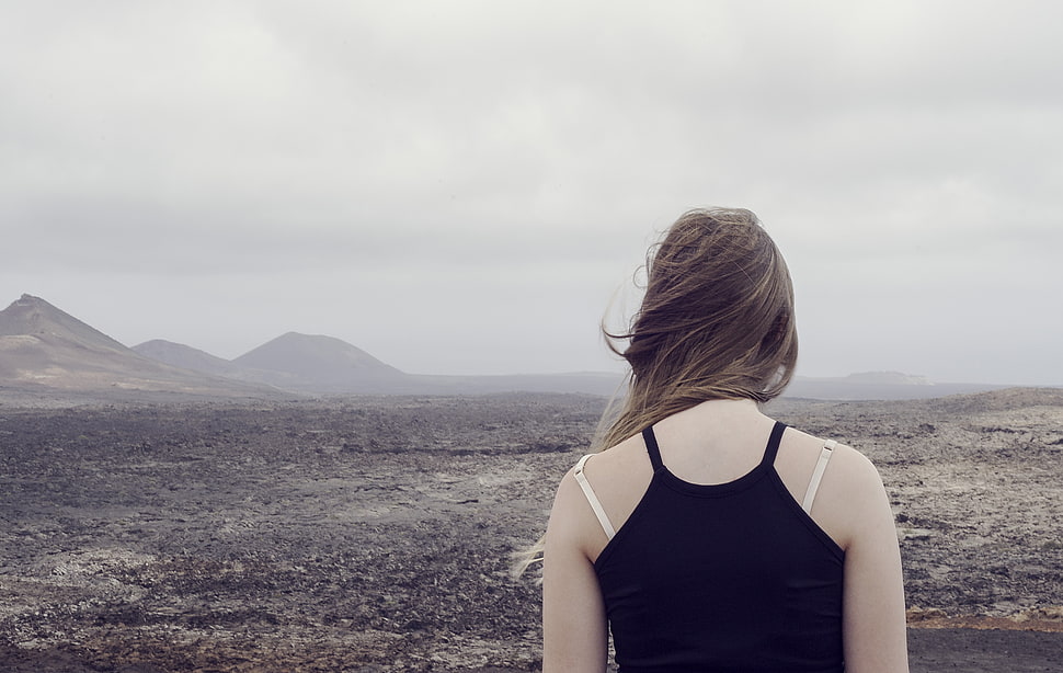 woman in black top standing facing mountains during daytime HD wallpaper