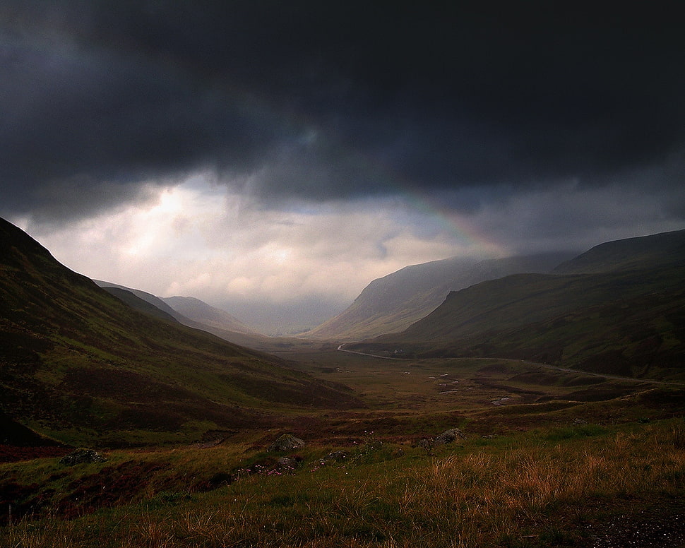 Mountain ranges under dark cloudy Skies HD wallpaper