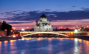 river in front of white and brown dome building at night time
