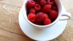 raspberries in white ceramic cup
