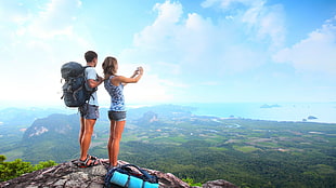 couple standing on top hill under blue cloudy sky during daytime