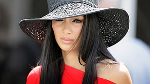 woman wearing red asymmetrical shoulder dress and gray hat