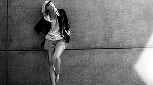grayscale photo of woman in black jacket and short shorts standing