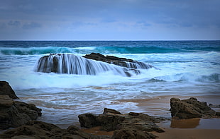 brown sand-beach, sea and rocks at daytime HD wallpaper