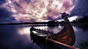 brown wooden dragon boat on body of water under cloudy sky