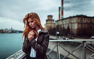 woman wearing black jacket and white top with beige building in background HD wallpaper