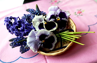 white and purple petaled flowers on round wicker basket
