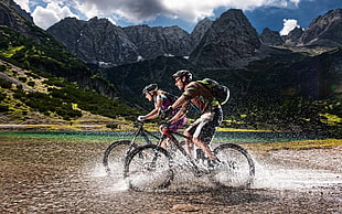 two man and woman riding on bike near mountains