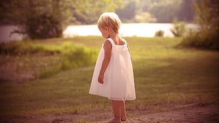 child standing on grass field during daytime HD wallpaper