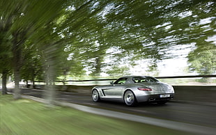 time lase photography of silver sports car on asphalt road near tree during daytime