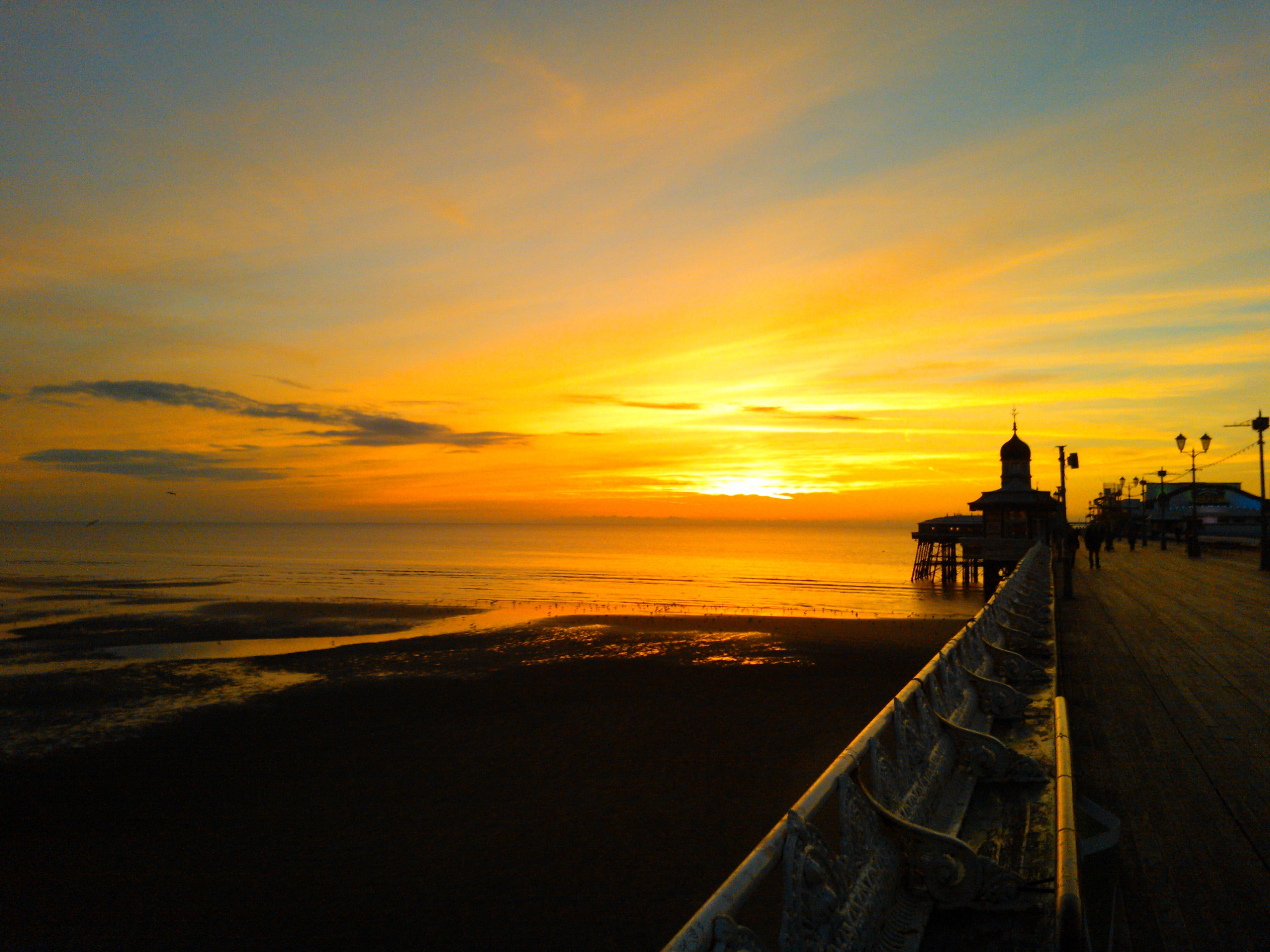 brown and gray building near body of water, sunset, sky, pier, sunlight