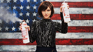 woman holding white labeled spray can