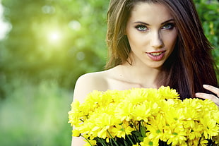 shallow focus photography of a brown haired woman holding yellow flower