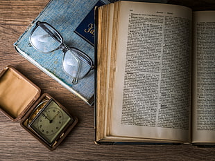 open book beside eyeglasses