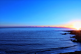 body of water under blue sky HD wallpaper