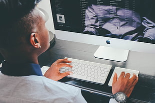 person wearing white top clothes facing iMac Pro
