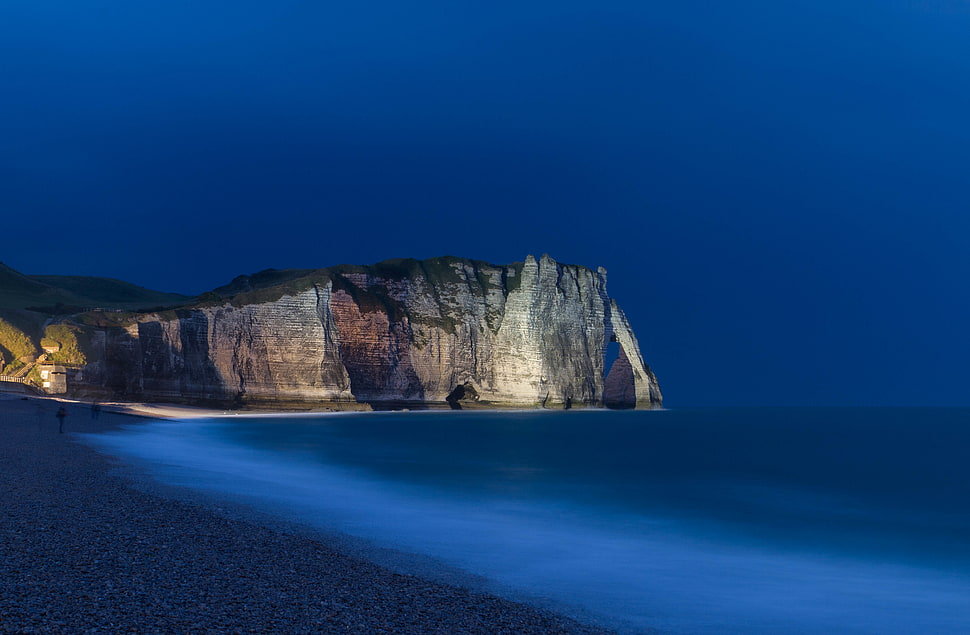 gray cliff near body of water during nighttime HD wallpaper