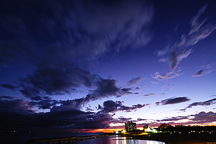 time-lapse photography of city lights turned on under blue sky